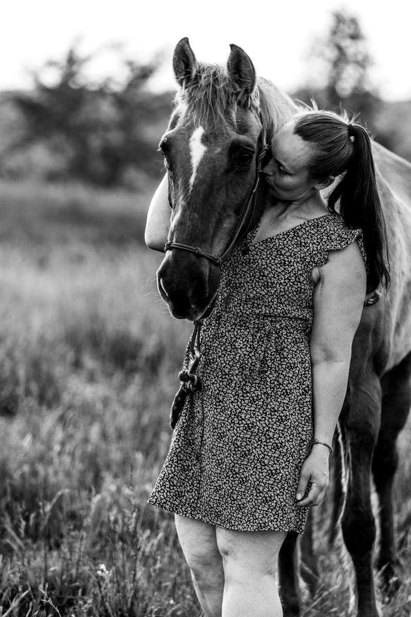 Woman hugging and kissing horse